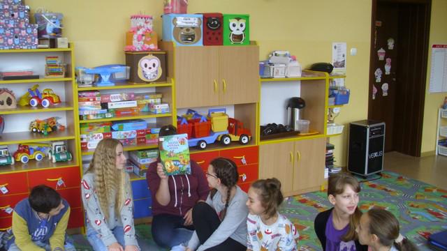 Uczniowie czytają przedszkolakom.